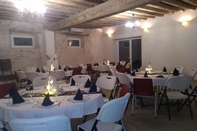 Chambre mansardée avec deux lits simples, un bureau en bois, une chaise blanche et une fenêtre de toit.