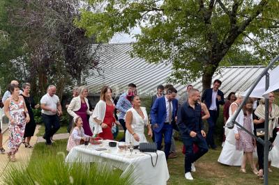 Un couple pose près d'une table décorée de fleurs et d'une pyramide de coupes de champagne dans une salle éclairée.