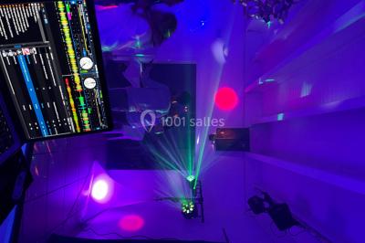 Un couple pose près d'une table décorée de fleurs et d'une pyramide de coupes de champagne dans une salle éclairée.