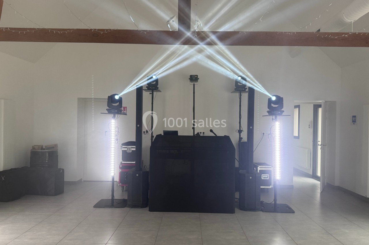 Installation de matériel de sonorisation et d'éclairage avec projecteurs et lumières dans une salle vide.