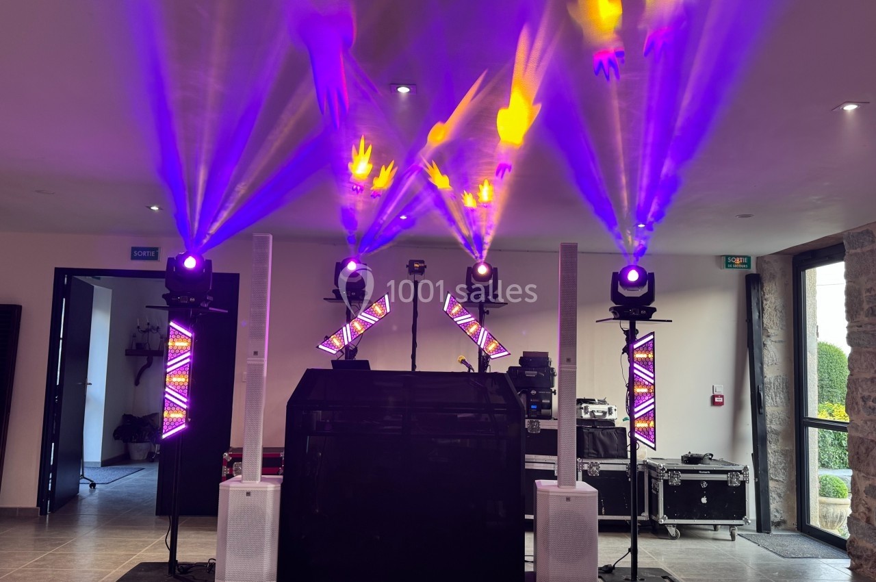 Installation de matériel d'éclairage et de sonorisation avec projecteurs colorés dans une salle intérieure.