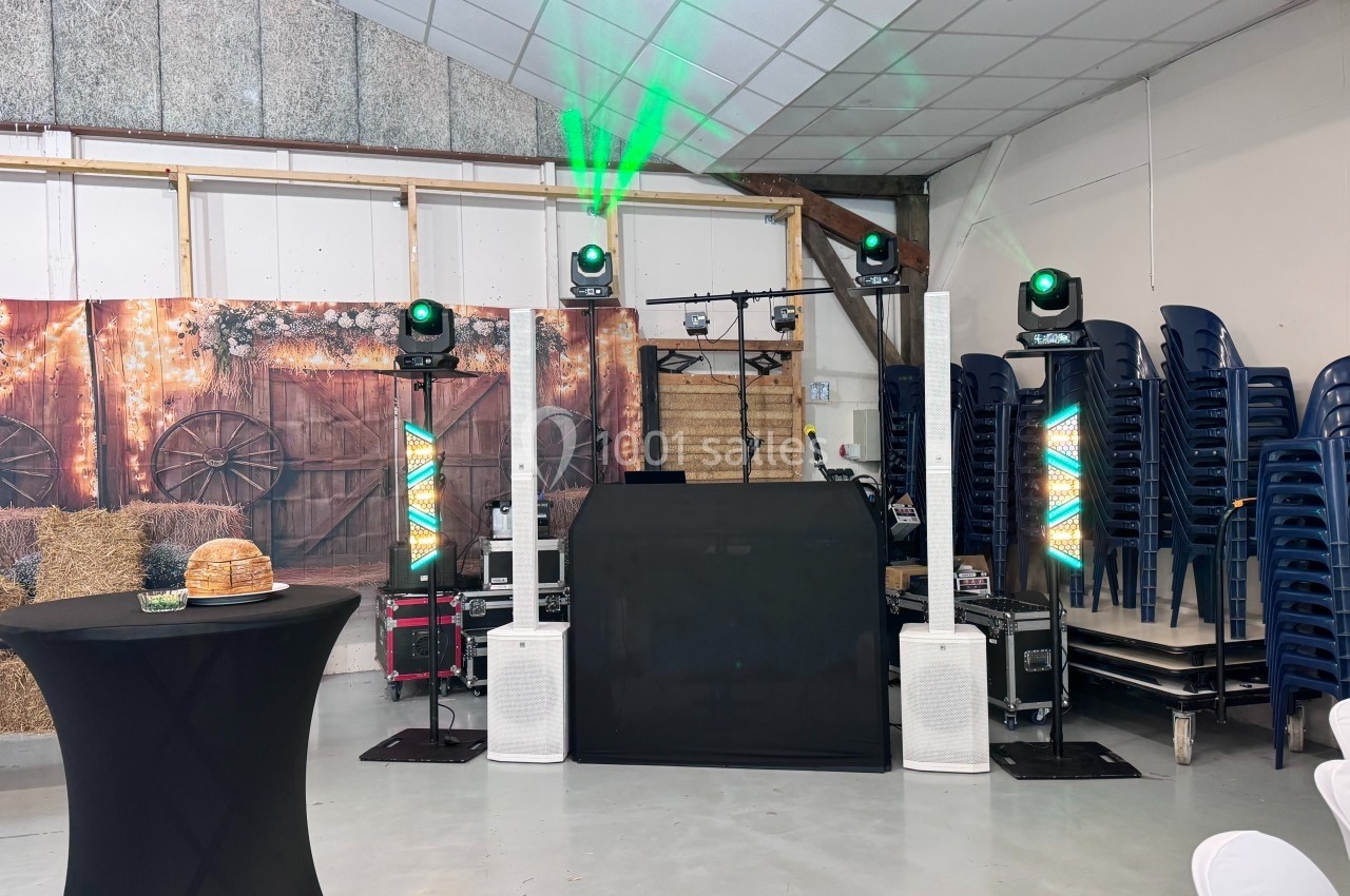 Installation de matériel de sonorisation et d'éclairage dans une salle décorée avec des éléments rustiques.