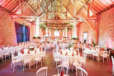 Voûtes en briques rouges soutenues par des colonnes en pierre dans une pièce au sol carrelé.