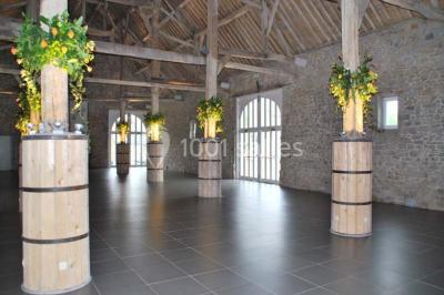 Voûtes en briques rouges soutenues par des colonnes en pierre dans une pièce au sol carrelé.