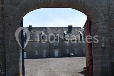 Voûtes en briques rouges soutenues par des colonnes en pierre dans une pièce au sol carrelé.