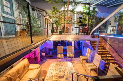 Escalier intérieur éclairé menant à un espace mezzanine, avec murs en pierre et plantes décoratives.