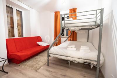 Chambre d'hôtel moderne avec lit double, murs verts, salle de bain attenante et mobilier contemporain.