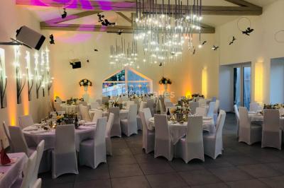 Chambre d'hôtel moderne avec lit double, murs verts, salle de bain attenante et mobilier contemporain.
