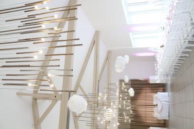 Chambre d'hôtel moderne avec lit double, murs verts, salle de bain attenante et mobilier contemporain.