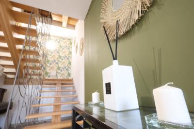 Chambre d'hôtel moderne avec lit double, murs verts, salle de bain attenante et mobilier contemporain.