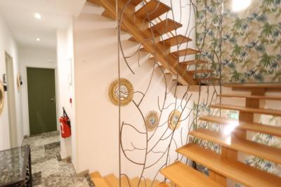 Chambre d'hôtel moderne avec lit double, murs verts, salle de bain attenante et mobilier contemporain.