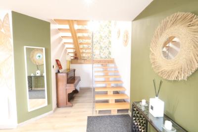 Chambre d'hôtel moderne avec lit double, murs verts, salle de bain attenante et mobilier contemporain.