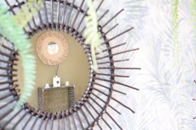 Chambre d'hôtel moderne avec lit double, murs verts, salle de bain attenante et mobilier contemporain.