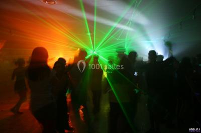 Miniature DJ Bourg-des-Comptes (Ille-et-Vilaine) - Animax 35 #10 Salle de réception décorée avec des tables rondes, nappes blanches, chaises ornées de nœuds beige et éclairage vert.