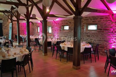 Miniature DJ Bourg-des-Comptes (Ille-et-Vilaine) - Animax 35 #19 Salle de réception décorée avec des tables rondes, nappes blanches, chaises ornées de nœuds beige et éclairage vert.