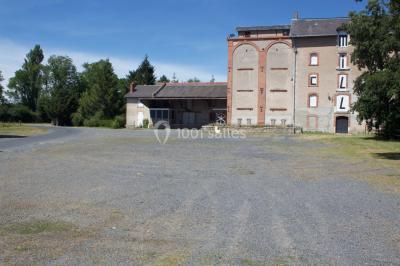 Salle de bain publique avec lavabos en inox, carrelage bleu et blanc, et portes de cabines fermées.