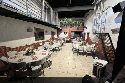 Salle de bain publique avec lavabos en inox, carrelage bleu et blanc, et portes de cabines fermées.