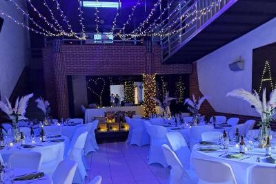 Salle de bain publique avec lavabos en inox, carrelage bleu et blanc, et portes de cabines fermées.