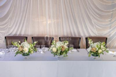 Salle de restaurant avec buffet circulaire, décorations lumineuses et grandes baies vitrées donnant sur un espace vert.
