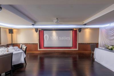 Salle de restaurant avec buffet circulaire, décorations lumineuses et grandes baies vitrées donnant sur un espace vert.