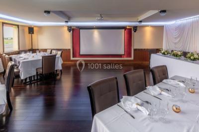 Salle de restaurant avec buffet circulaire, décorations lumineuses et grandes baies vitrées donnant sur un espace vert.