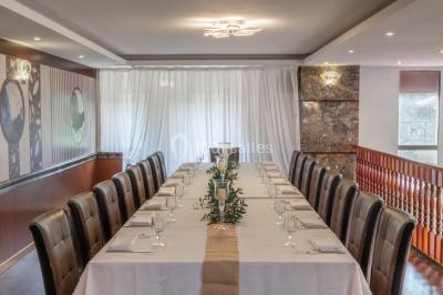 Salle de restaurant avec buffet circulaire, décorations lumineuses et grandes baies vitrées donnant sur un espace vert.