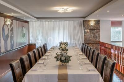 Salle de restaurant avec buffet circulaire, décorations lumineuses et grandes baies vitrées donnant sur un espace vert.