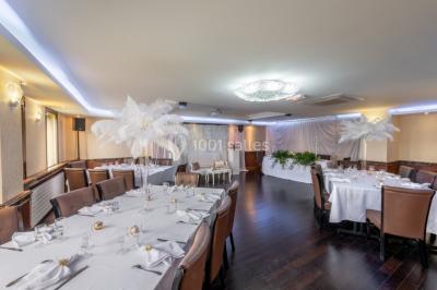 Salle de restaurant avec buffet circulaire, décorations lumineuses et grandes baies vitrées donnant sur un espace vert.