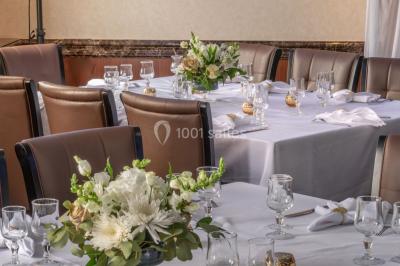 Salle de restaurant avec buffet circulaire, décorations lumineuses et grandes baies vitrées donnant sur un espace vert.