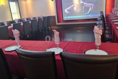 Salle de restaurant avec buffet circulaire, décorations lumineuses et grandes baies vitrées donnant sur un espace vert.