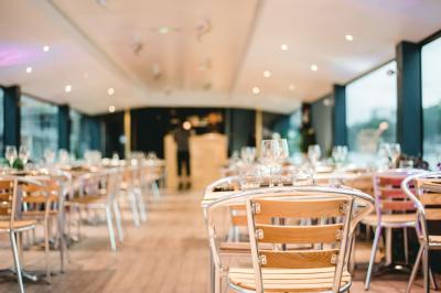 Espace extérieur d'un bateau avec fauteuils modernes, table basse, bouée de sauvetage et vue sur une rivière et un pont.