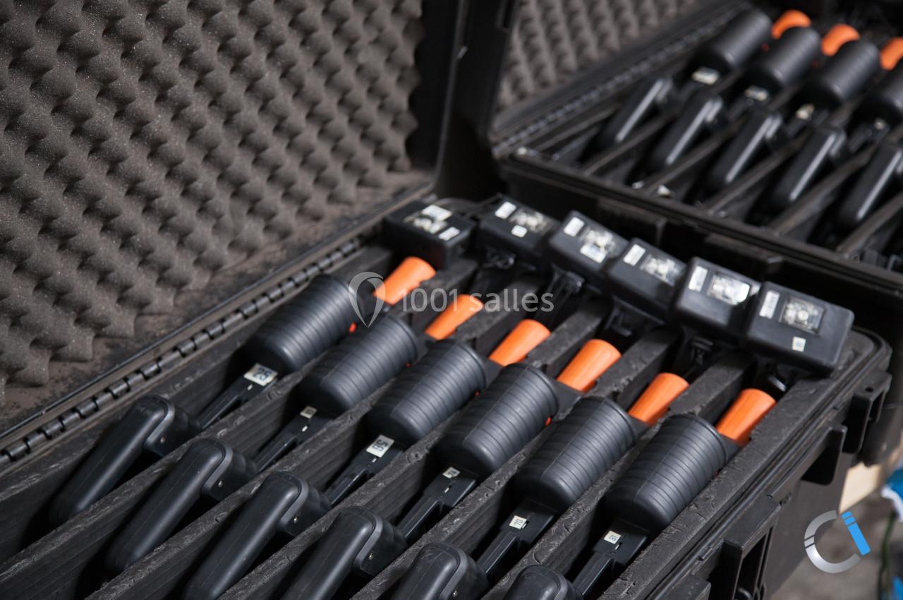 Valises ouvertes contenant plusieurs outils noirs avec poignées orange, rangés dans des compartiments en mousse.