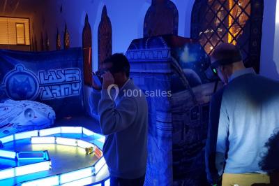 Flammes vives s'élevant d'un feu de bois sous une grille métallique, entourées de pierres sombres.