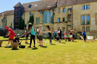 Flammes vives s'élevant d'un feu de bois sous une grille métallique, entourées de pierres sombres.