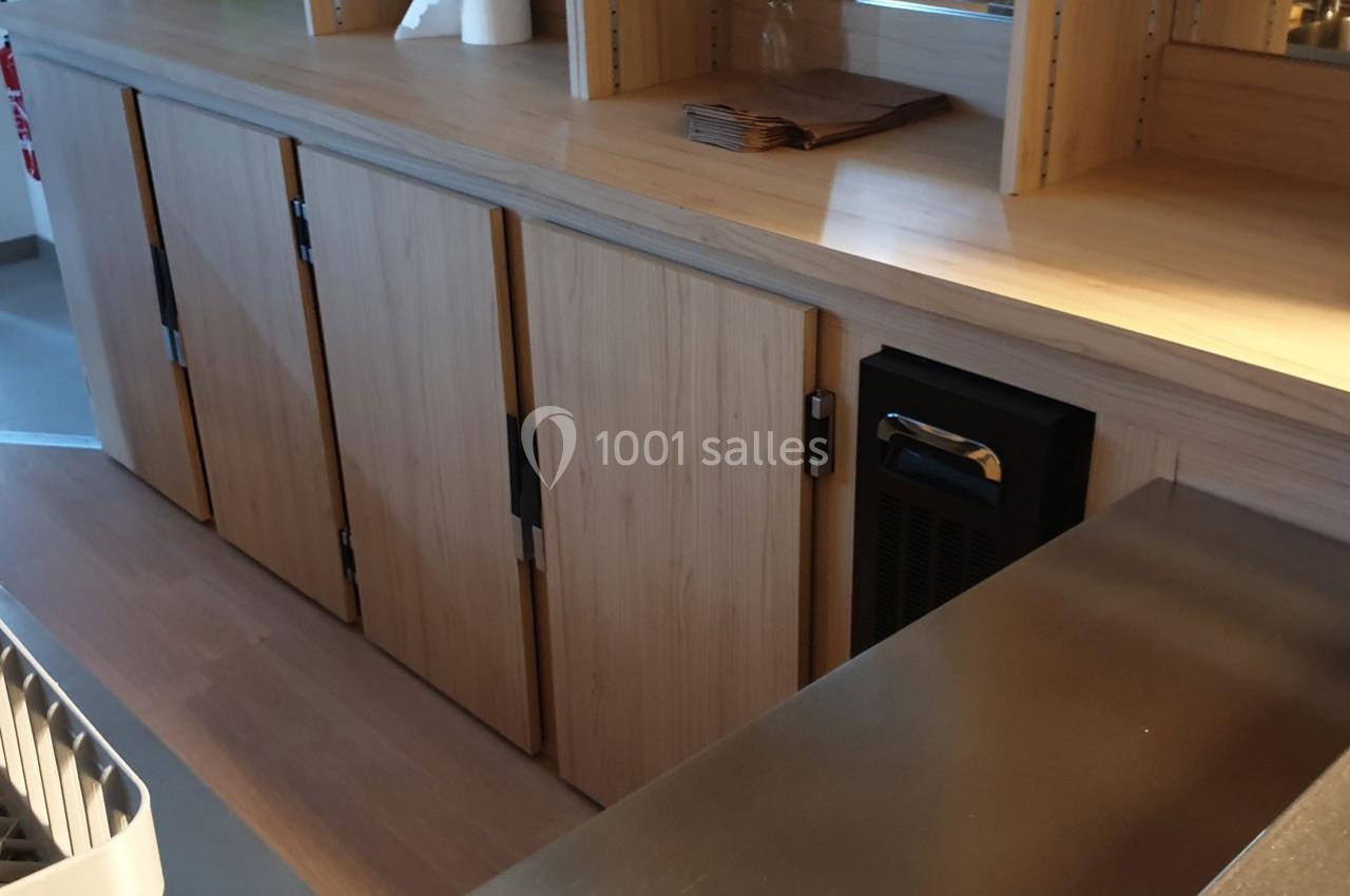 Meuble en bois clair avec plusieurs portes fermées, situé dans un espace intérieur moderne et lumineux.