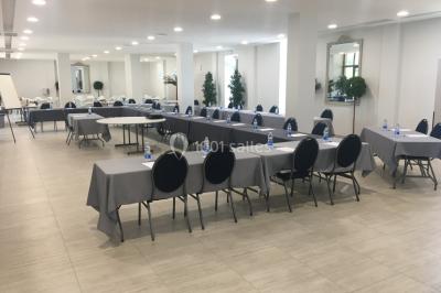 Un hélicoptère posé sur une pelouse, entouré d'arbres et de bâtiments en arrière-plan.