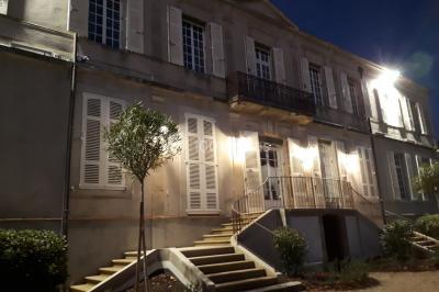 Un hélicoptère posé sur une pelouse, entouré d'arbres et de bâtiments en arrière-plan.