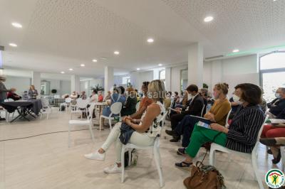 Un hélicoptère posé sur une pelouse, entouré d'arbres et de bâtiments en arrière-plan.