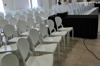 Un hélicoptère posé sur une pelouse, entouré d'arbres et de bâtiments en arrière-plan.