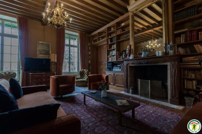 Un hélicoptère posé sur une pelouse, entouré d'arbres et de bâtiments en arrière-plan.