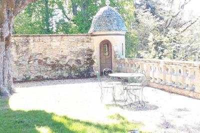 Un hélicoptère posé sur une pelouse, entouré d'arbres et de bâtiments en arrière-plan.