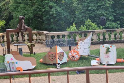 Un hélicoptère posé sur une pelouse, entouré d'arbres et de bâtiments en arrière-plan.