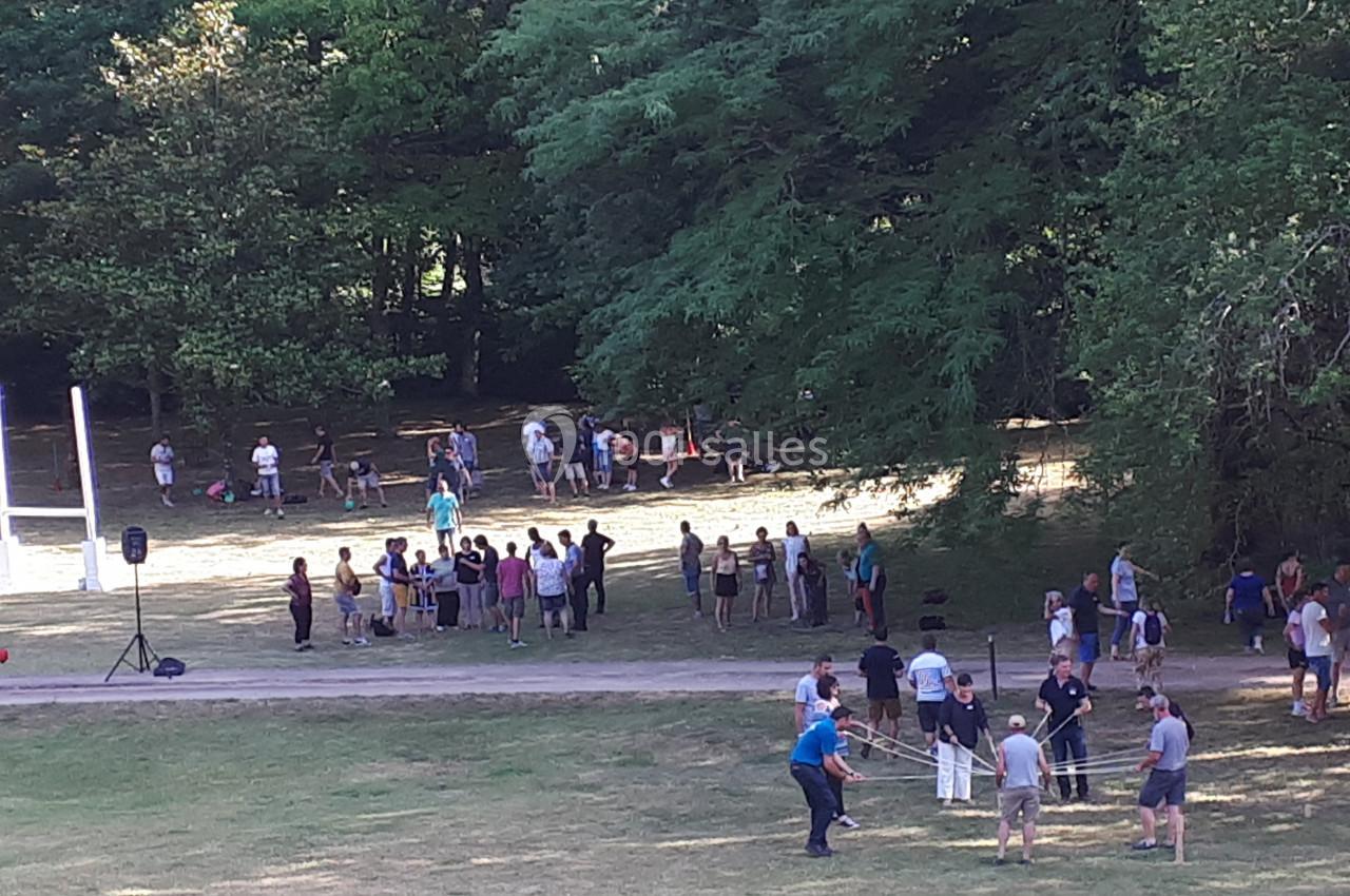 Groupe de personnes participant à des activités en plein air dans un parc verdoyant par une journée ensoleillée.