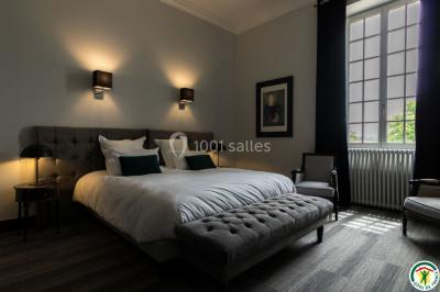 Un hélicoptère posé sur une pelouse, entouré d'arbres et de bâtiments en arrière-plan.