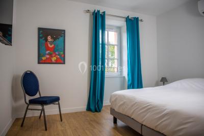 Un hélicoptère posé sur une pelouse, entouré d'arbres et de bâtiments en arrière-plan.