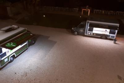 Un hélicoptère posé sur une pelouse, entouré d'arbres et de bâtiments en arrière-plan.