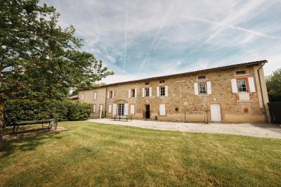 Un hélicoptère posé sur une pelouse, entouré d'arbres et de bâtiments en arrière-plan.