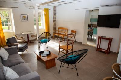 Un hélicoptère posé sur une pelouse, entouré d'arbres et de bâtiments en arrière-plan.