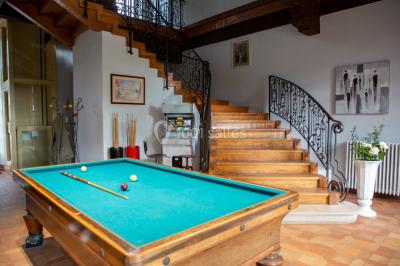 Un hélicoptère posé sur une pelouse, entouré d'arbres et de bâtiments en arrière-plan.