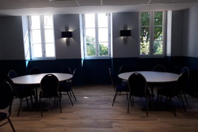 Un hélicoptère posé sur une pelouse, entouré d'arbres et de bâtiments en arrière-plan.